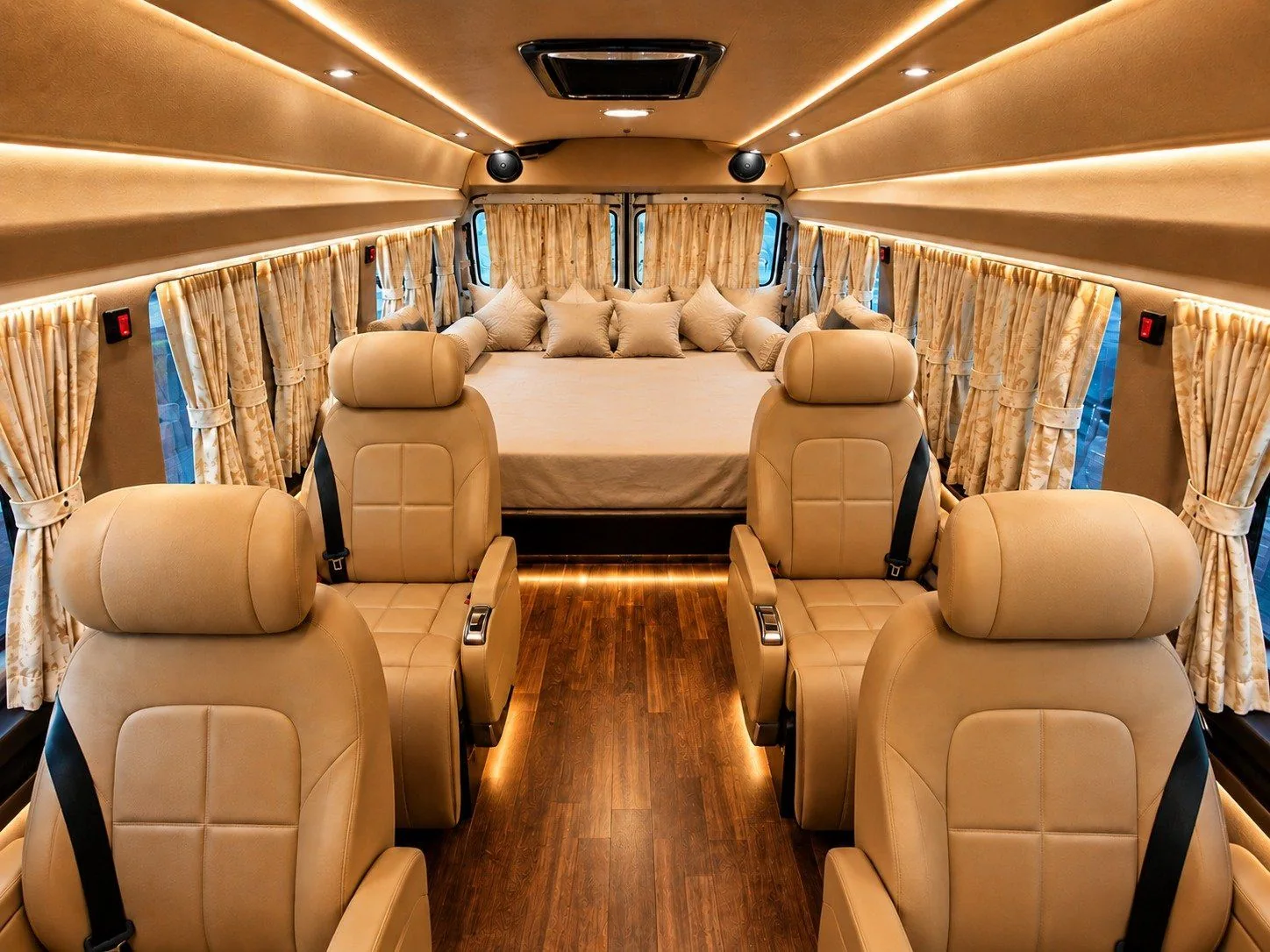 The Roving Suites vehicle cabin, showing four reclining seats with seat belts, the central aisle and the rear resting arrangement